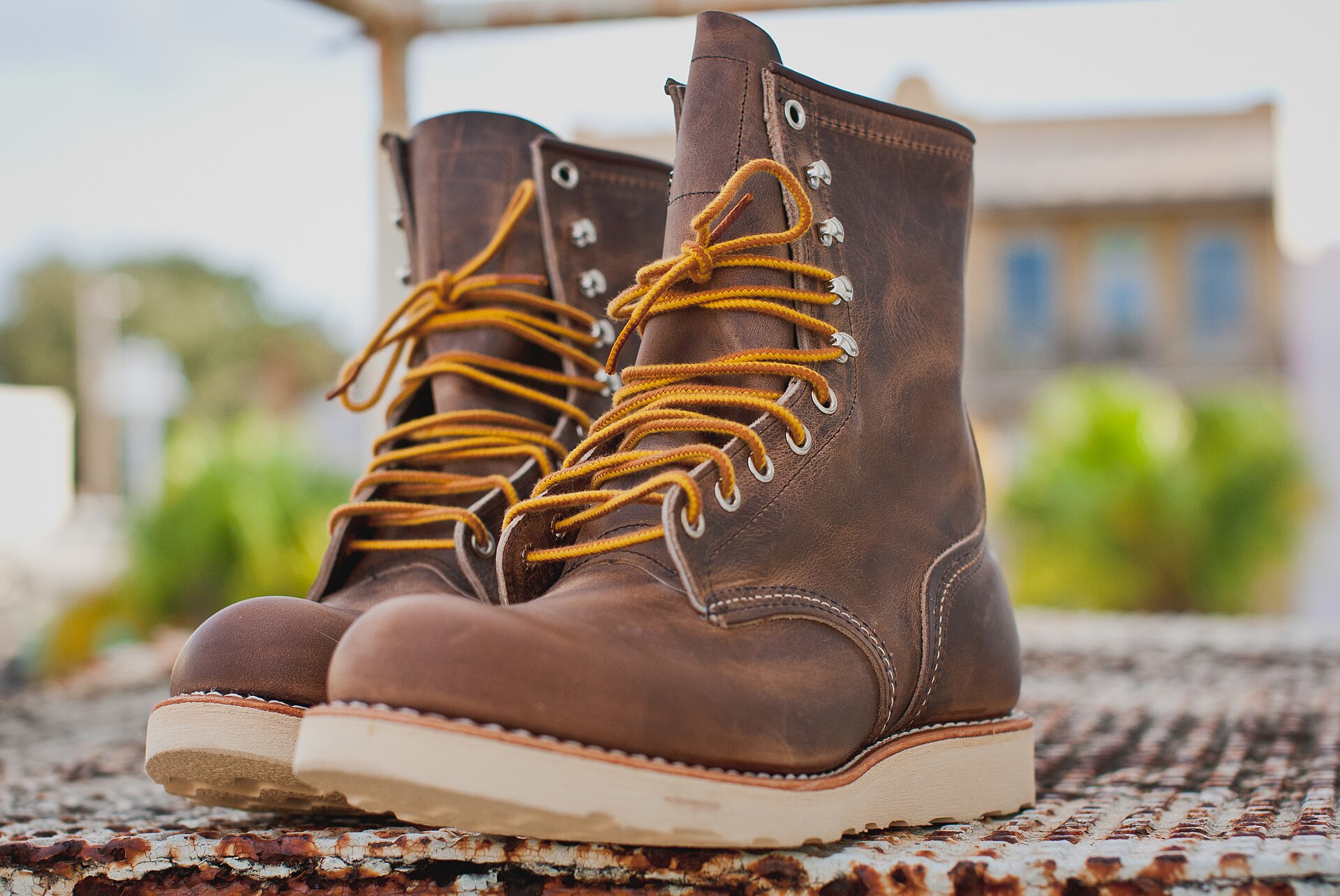 A pair of brown Red Wing Heritage lace-up boots on a stone ledge; the exact models are unconfirmed